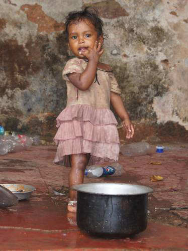 Child from Margao on the Street Path next to their cooking pot