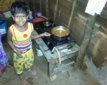 One of the young children helping with the cooking on their new gas stove