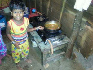 One of the young children helping with the cooking on their new gas stove